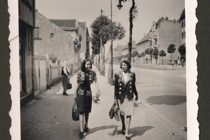 Historische Fotografie, die zwei Schwarze Frauen zeigt, die auf einem Gehweg laufen. 